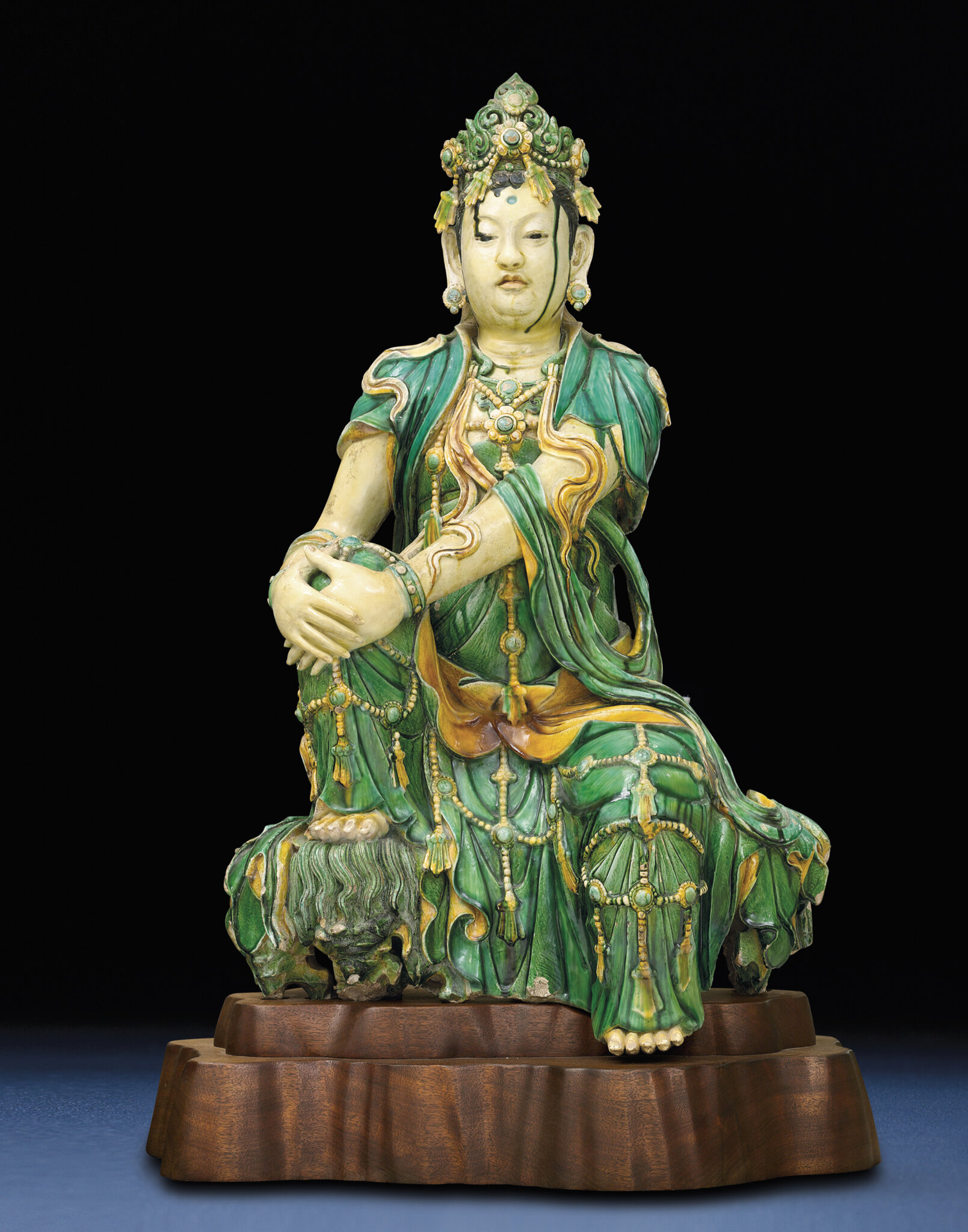 A rare Ming sancai glazed stoneware figure of Guanyin, Ming