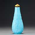 An inscribed pale blue glass 'lotus-design' snuff bottle. Probably Imperial, attributable to Beijing, Guangxu engraved four-char