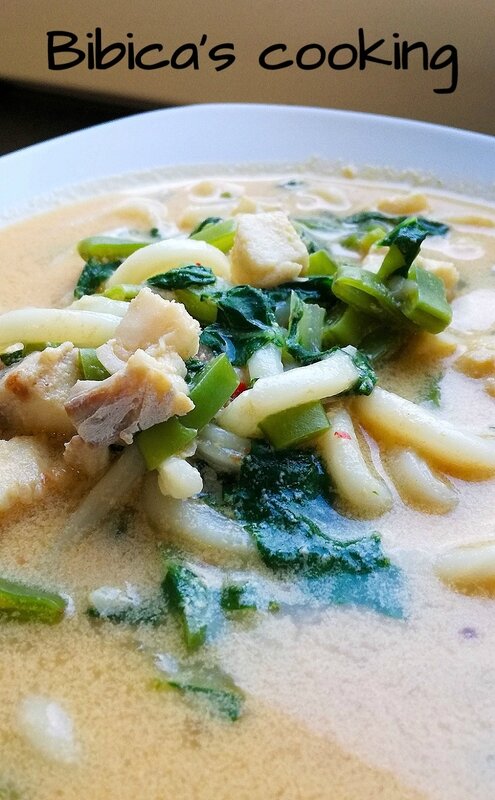 Soupe à la noix de coco à l'églefin, nouilles udon, haricots plats, pak-choï et sauce soja gros plan