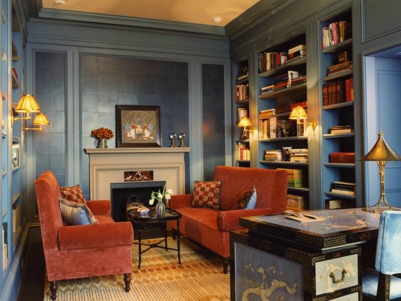 traditional-living-room-design-with-blue-painted-wooden-wall-library-shelves-and-fireplace-plus-oval-black-polished-metal-coffee-table-as-well-as-red-fabric-couch