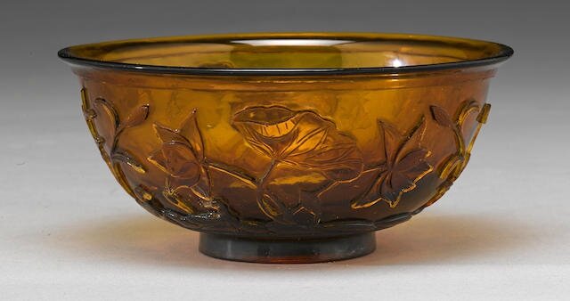 A translucent golden amber glass bowl with carved decoration, Qianlong four-character mark and of the period