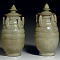 A pair of <b>Zhejiang</b> celadon carved five-spout jars and covers, Northern Song dynasty, 11th-12th century