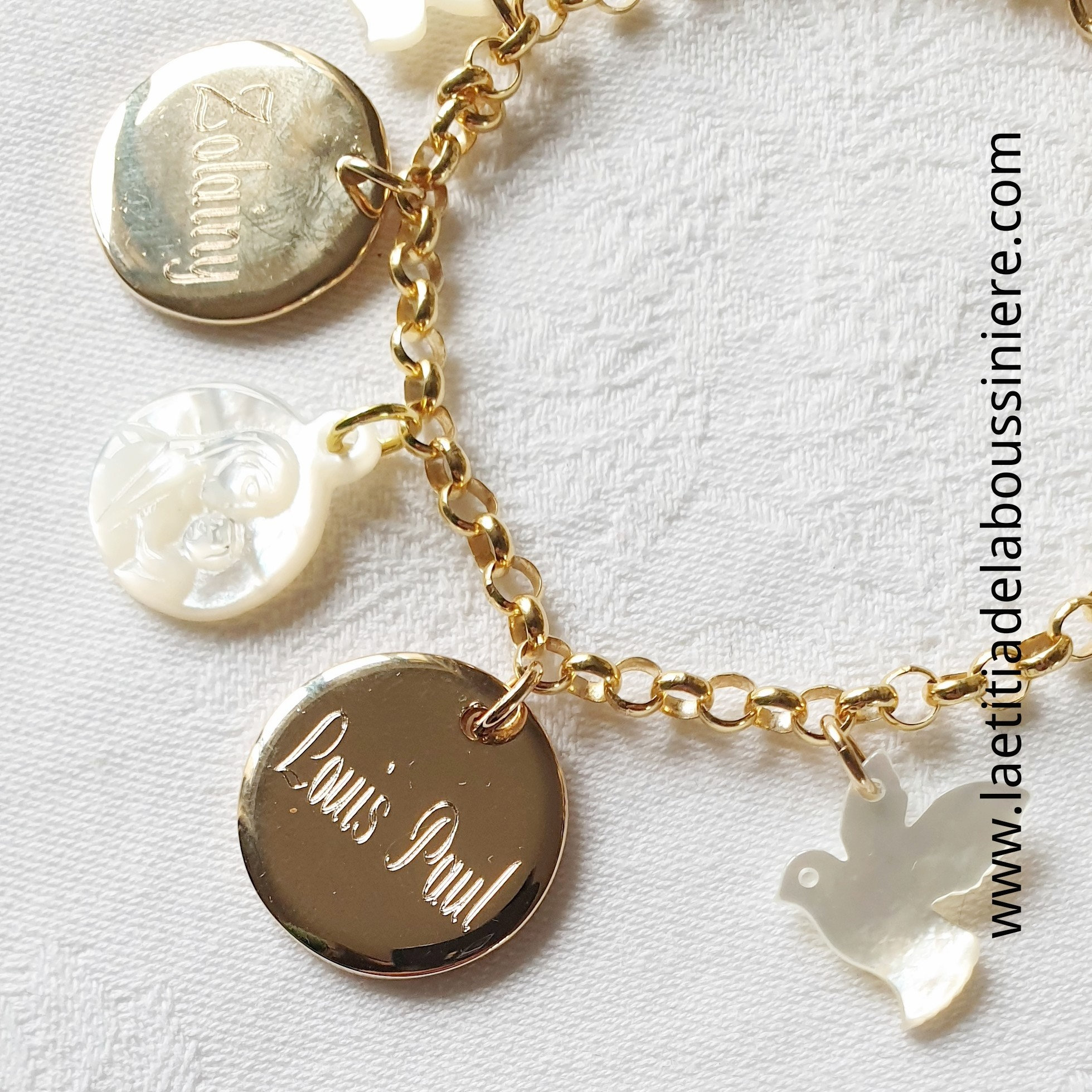 Bracelet personnalisé sur chaîne plaqué or maille classique composé de 2 colombes en nacre, 2 médailles en plaqué or gravées à la machine et une médaille de Vierge à l'Enfant en nacre (détail)