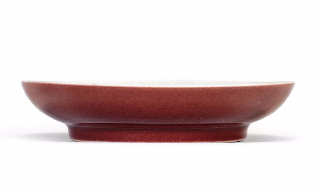 A red-glazed saucer-dish, Yongzheng six-character mark and of the period (1723-1735)
