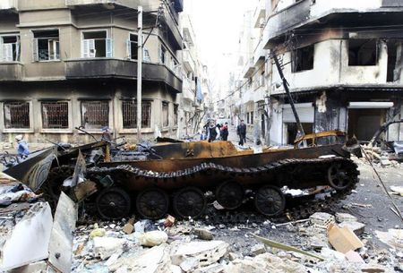 863495_a-damaged-armoured-vehicle-belonging-to-the-syrian-army-is-seen-in-a-street-in-homs