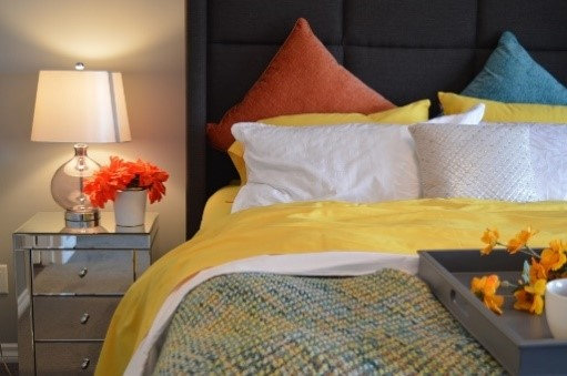 Des coussins de divers modèles et coloris posés sur un lit
