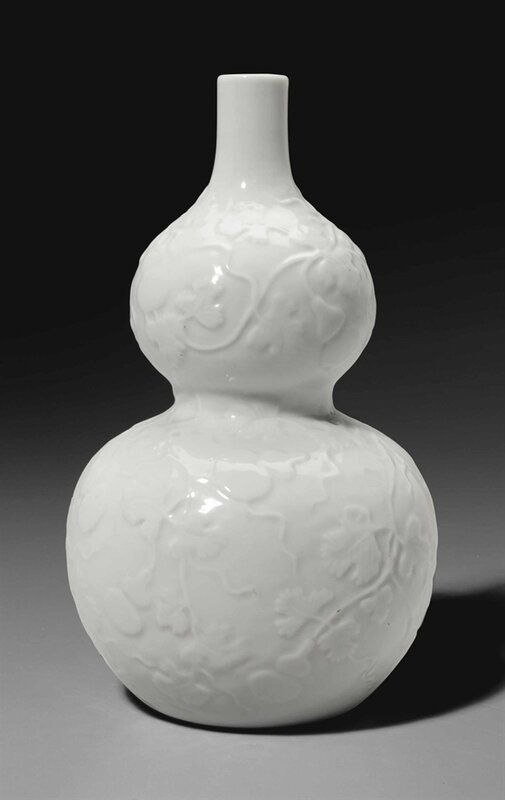 A very rare small white-glazed relief-decorated double-gourd vase, Yongzheng six-character mark in underglaze blue and of the period (1723-1735)