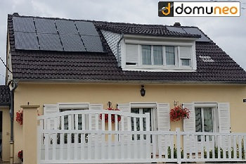 une maison avec tuiles en ardoises et des panneaux solaires