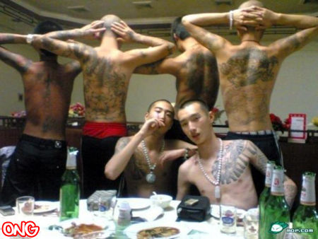 chinese_black_society_gang_triad_shirtless_showing_off_tattoos_in_restaurant_500x375