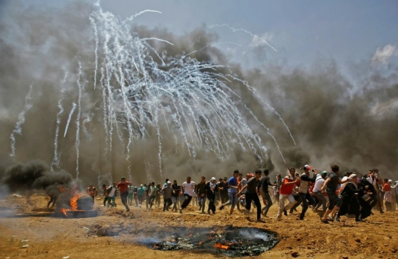1121439-des-manifestants-palestiniens-courent-pour-echapper-aux-gaz-lacrymogenes-lors-d-affrontements-avec-l