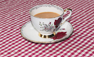 cup_of_tea_and_cream_on_checkered_table_cloth