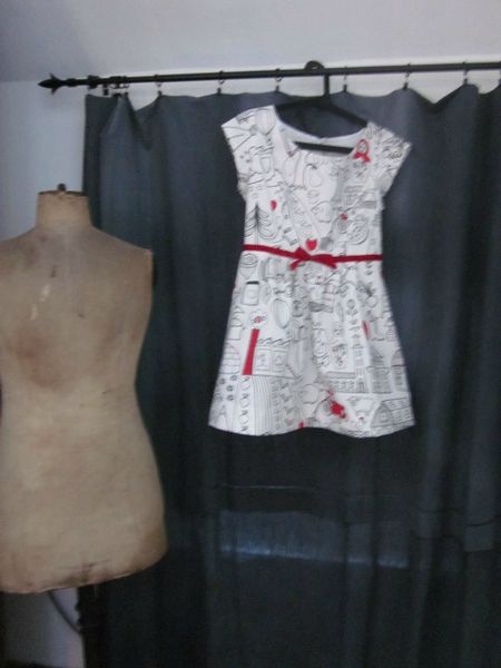 Robe en coton blanc imprimé dessins enfantins noirs colorisés de rouge avec haut à découpes princesse et jupe plissée réhaussée d'une ceinture de ruban de velours rouge - taille 36 (5)