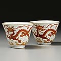 A pair of iron-red '<b>dragon</b>' <b>wine</b> <b>cups</b>, Qianlong seal marks and period (1736-1795)