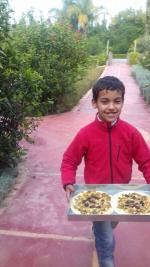 Mouad emmène les pizzas préparées vers le four