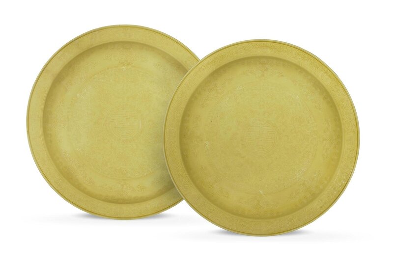 A pair of magnificent and rare large Imperial yellow-glazed incised 'Auspicious Emblems' dishes, Yongzheng six-character marks and of the period (1723-1735)