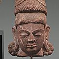 Tête de divinité en <b>grès</b> <b>gris</b>, la coiffe surmonté d'un haut chapeau. Vietnam, art Cham XIIe-XIIIe siècles