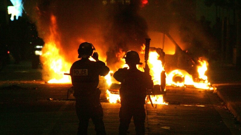 des-policiers-sont-postes-a-proximite-de-vehicules-incendies-le-28-octobre-2005-a-clichy-sous-bois_5451571