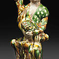 A sancai-glazed figure of a woman <b>holding</b> a goose, Tang dynasty (AD 618-907)