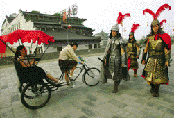 Des_touristes_s_essaient___la_conduite_d_un_tricycle_sur_la_terrasse_des_remparts_de_Xi_an