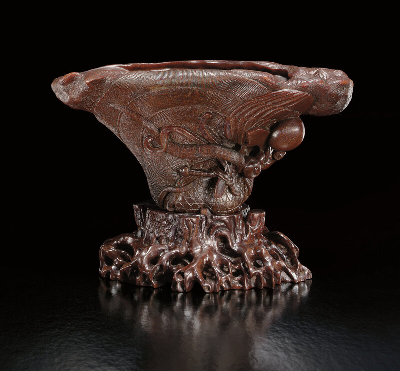 An extremely rare and finely carved rhinoceros horn 'Wood grain and an baxian' libation cup, Ming dynasty, 17th century