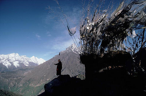 Un moine tibétain contemple la vallée du Khumbu depuis un rocher surplombant le monastère de Thangboche
