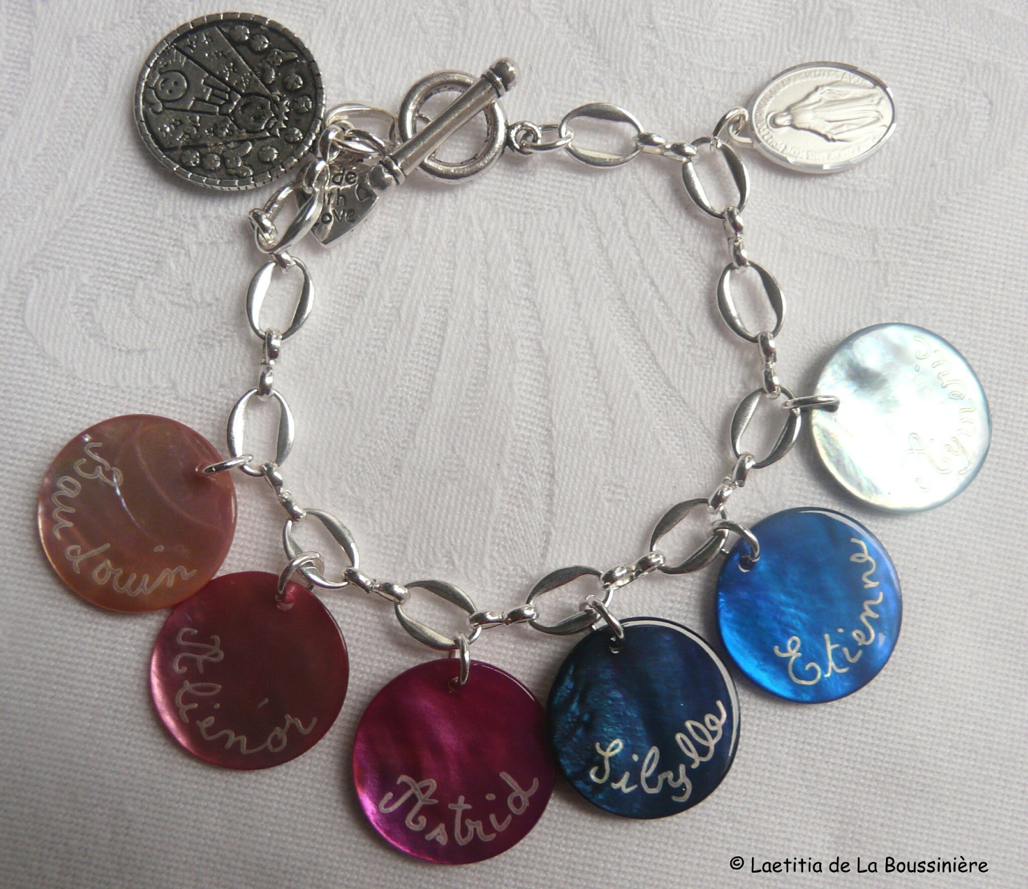 Bracelet sur chaîne ovale métal composé de 6 médailles en nacre gravées et une médaille miraculeuse en argent massif