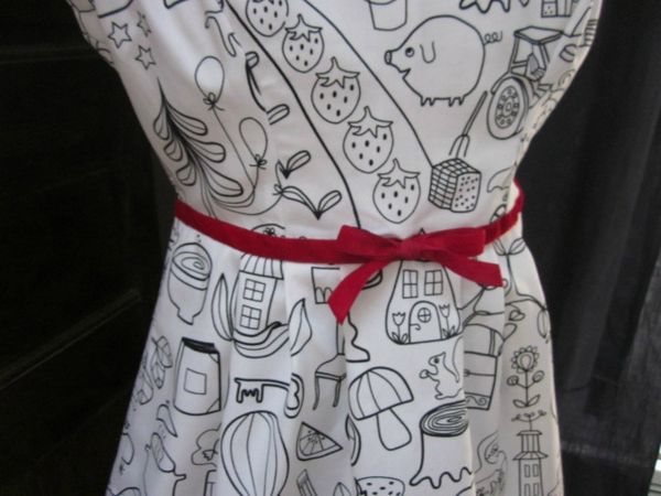 Robe en coton blanc imprimé dessins enfantins noirs colorisés de rouge avec haut à découpes princesse et jupe plissée réhaussée d'une ceinture de ruban de velours rouge - taille 36 (4)