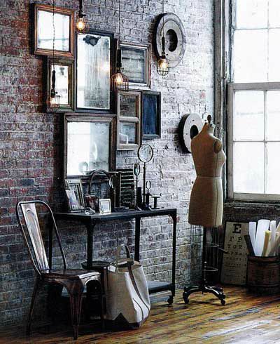 Espejos en pared de ladrillo y silla Tolix vintage