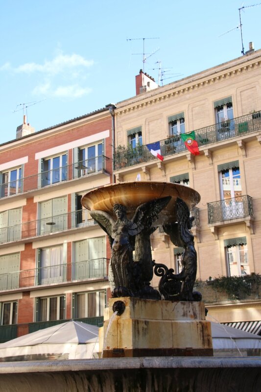 Fontaine place de la trinité et drapeaux Portugais et Français