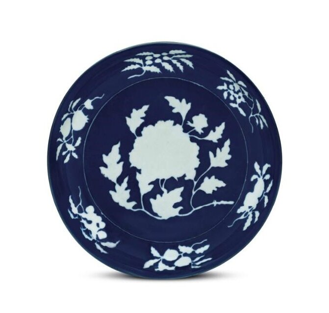 An exceptionally rare large blue and white reserve-decorated ‘peony’ dish, Xuande six-character mark in underglaze blue in a line and of the period (1426-1435)