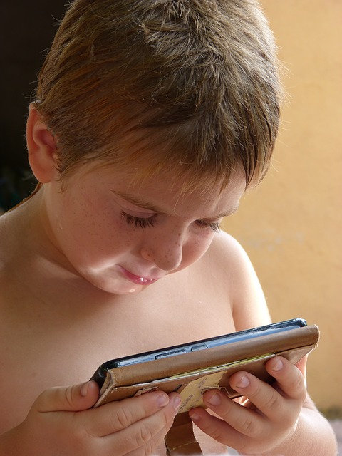 un enfant regardant et jouant sur un mobile