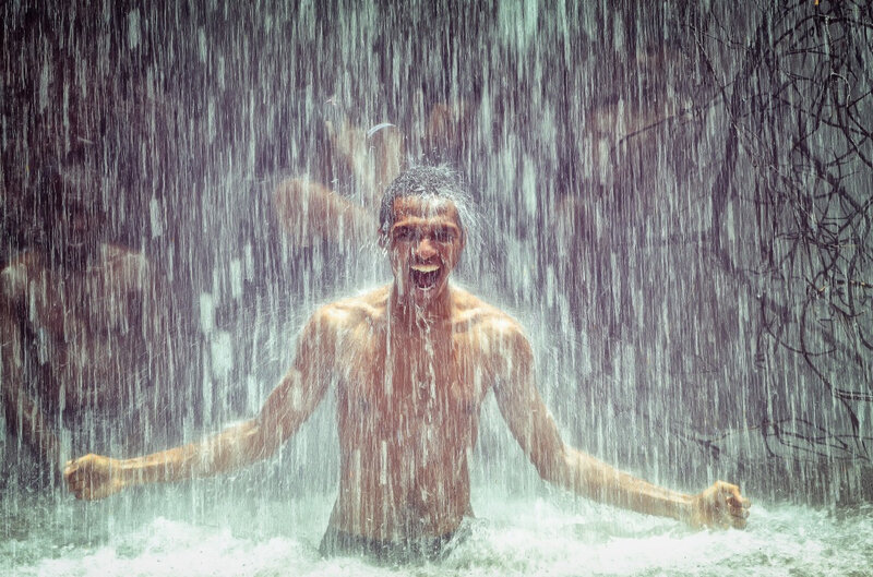 homme sous une cascade