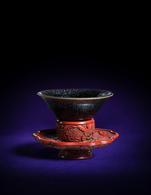 An exceptionally rare and large heirloom black-glazed 'yuteki tenmoku' tea bowl, Southern Song dynasty and a cinnabar lacquer 'floral' bowl stand, Ming dynasty, early 15th century