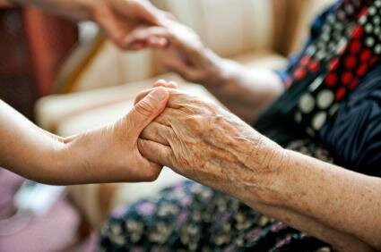 151009-425x282-Volunteer-holding-elderly-persons-hands