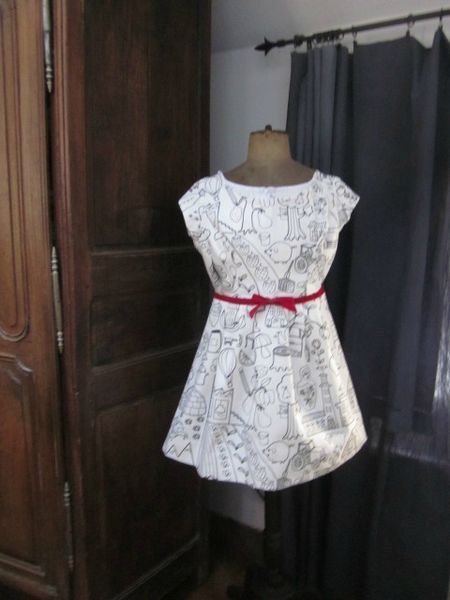 Robe en coton blanc imprimé dessins enfantins noirs colorisés de rouge avec haut à découpes princesse et jupe plissée réhaussée d'une ceinture de ruban de velours rouge - taille 36 (1)