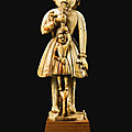 A carved ivory <b>standing</b> <b>figure</b> with parakeet and cup-bearer, probably Goa, 17th century