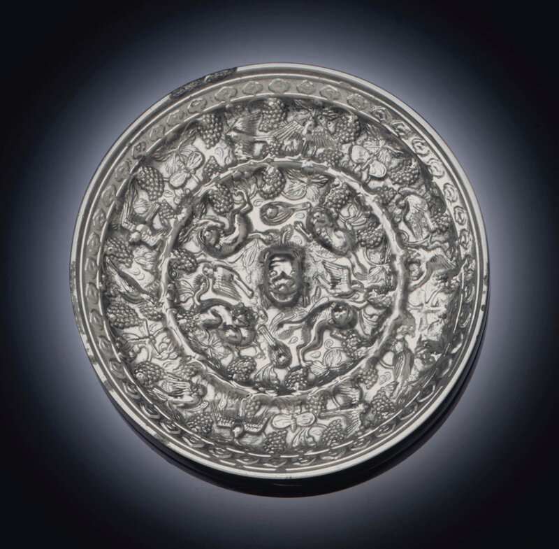 A small silvery bronze 'Lion and Grapevine' mirror, Tang dynasty (618-907)