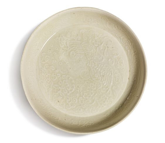A finely molded 'Ding' 'peacock' saucer dish, Northern Song-Jin dynasty (930-1234)