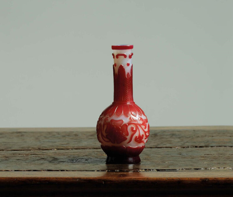 A very rare Imperial small ruby-red overlay white glass ‘mallow flower’ bottle vase, Qianlong incised six-character mark in a line and of the period (1736-1795)