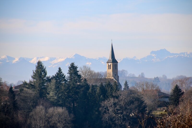 Les Pyrénées enneigées derrière l'église de Cassagne