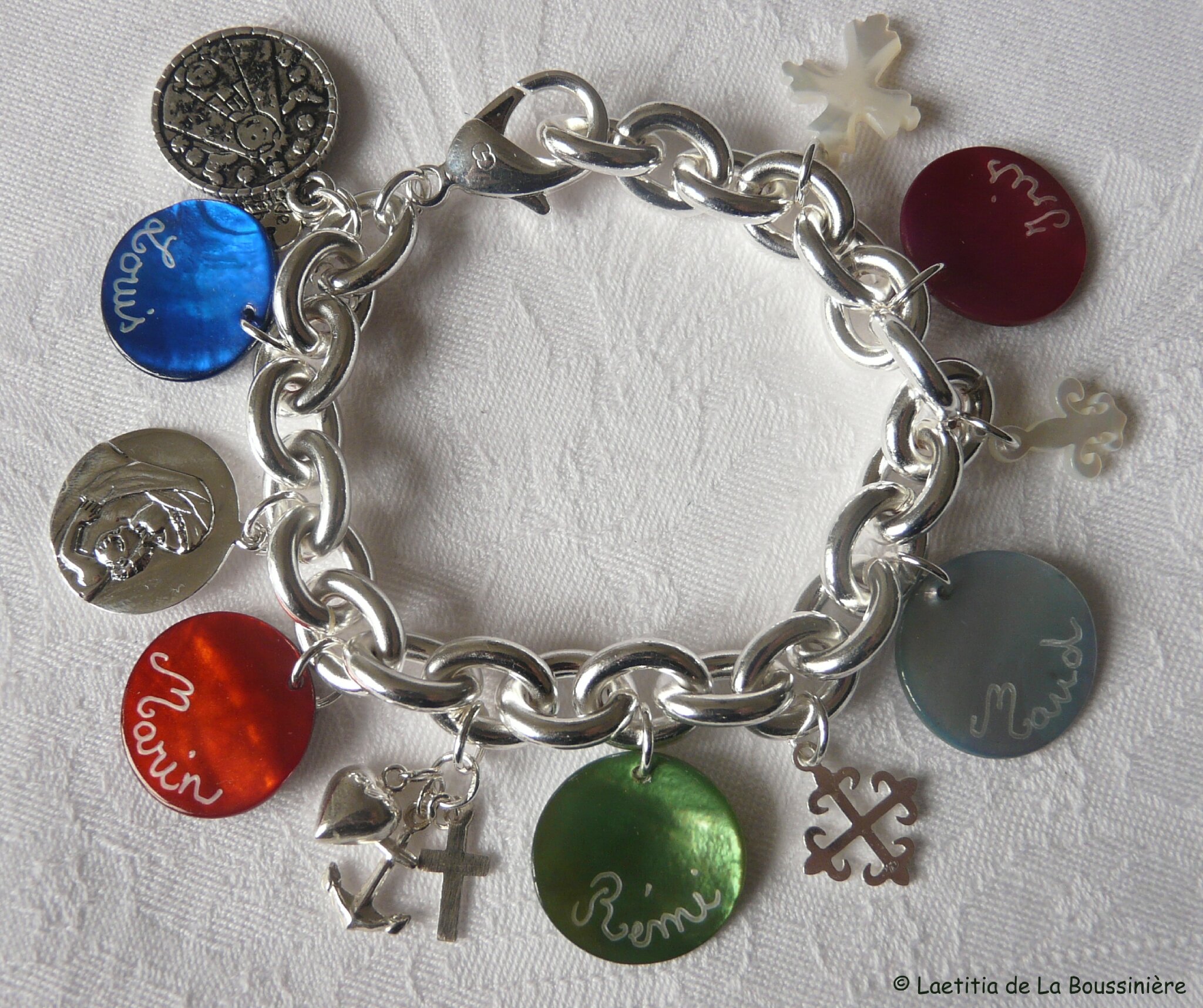 Bracelet sur chaîne plaqué argent ovale 5 médailles de nacre gravées, 1 médaille de Vierge à l'Enfant en argent massif 19 mm, 1 Vertus Théologales en argent massif, 1 Croix occitane en argent massif, 1 Fleur de lys en nacre et 1 Croix de Jérusalem en nacre
