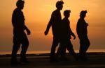 US_Navy_021029-N-4309A-012_Crewmembers_walk_across_the_ship^rsquo,s_flight_deck_before_the_sun_sets_over_the_Arabian_Sea