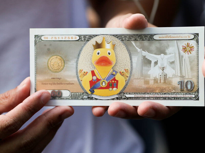 Un faux billet de banque représentant un canard lors d’un rassemblement prodémocratie exigeant que le roi de Thaïlande rende les actifs royaux au peuple, à Bangkok, le 25 novembre 2020