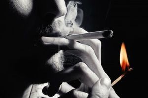 9771059-hommes-main-lumieres-une-cigarette-avec-un-gros-plan-de-match