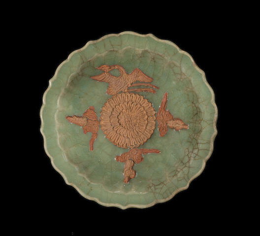 A celadon-glazed and biscuit-decorated barbed-rim dish, 14th century