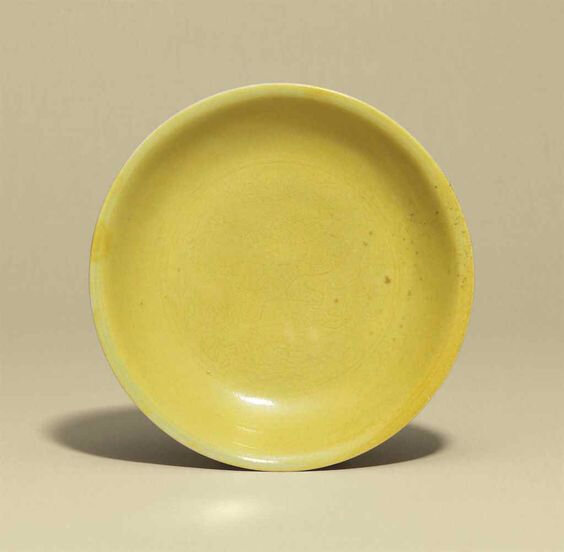 A yellow-glazed incised 'dragon' dish, Jiajing six-character mark in underglaze blue within a double circle and of the period (1522-1566)