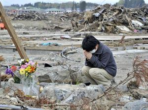 103753_une-proche-de-victimes-du-tsunami-se-recueille-a-minamisoma-pres-de-fukushima-le-2-mai-2011