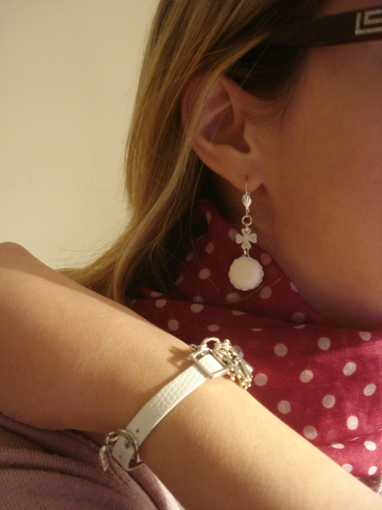 Les boucles d'oreilles et le bracelet blancs de Constance