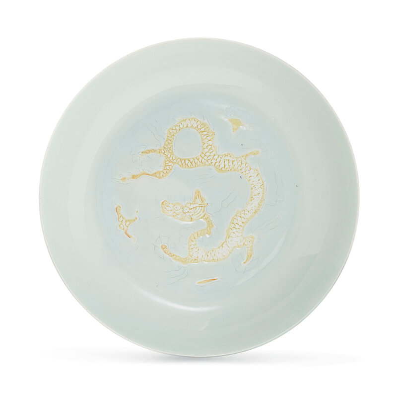 A rare white-glazed biscuit-decorated 'dragon' dish,Hongzhi six-character mark in underglaze blue within a double circle and of the period (1488-1505)