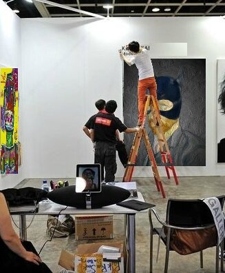 322290_des-ouvriers-installent-des-tableaux-pour-art-hk-la-grande-foire-d-art-contemporain-de-hong-kong-le-15-mai-2012